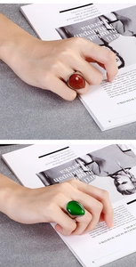 Teardrop gemstone rings in gold-sand and green cat's eye stone worn on hand