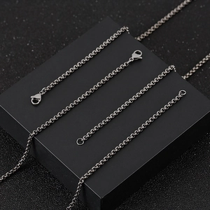 Photo de plusieurs chaînes à maillons O en acier inoxydable sur un socle cube noir