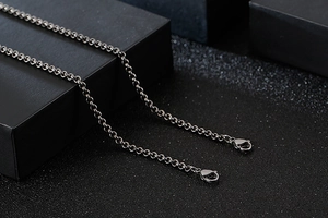 Detail of a dark silver stainless steel rolo chain necklace with dual lobster clasps