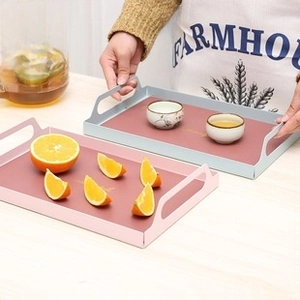 Detail of vintage tin metal snack trays with cutout handles in pink and blue colors