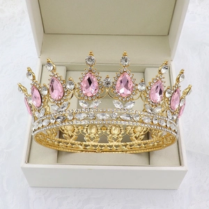 Detailed view of baroque gold crown with pink teardrop gems in a jewelry box