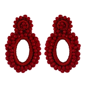 Macro detail of red seed bead earrings with handmade bohemian woven texture