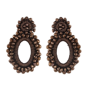 Macro view of handmade bohemian brown seed bead earrings with woven textures
