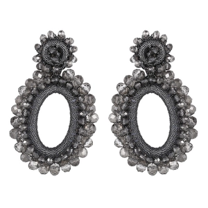 Detail of bohemian oval hoop earrings featuring faceted grey glass beads and handwoven texture