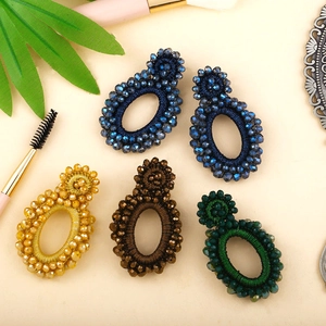 Flat lay of five handmade bohemian seed bead earrings in various vintage colors