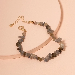 Bohemian irregular turquoise stone bracelet with adjustable gold lobster clasp on pedestal