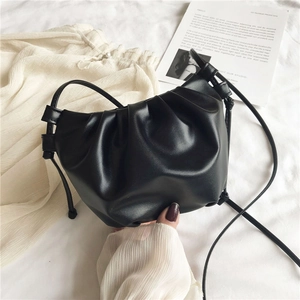Detail view of small black PU leather cloud bag with soft ruched texture and slim strap