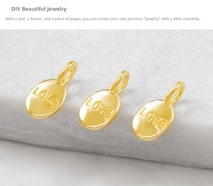 Macro view of three golden oval LOVE pendant charms for DIY jewelry making