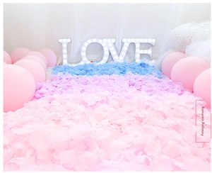 Romantic wedding walkway with pink and purple artificial petals and glowing LOVE lights