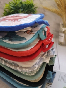 Close-up of thick quilted cotton heat insulation pads with hanging loops in various colors