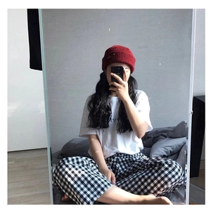 Winter outfit featuring a red knit beanie and black and white checkered lounge pants