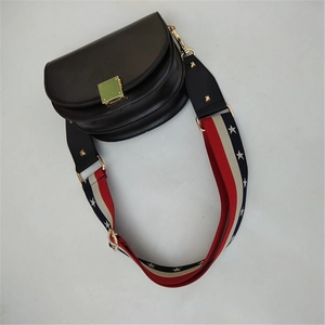 Detail of a black leather saddle bag featuring a red white and blue star pattern wide strap