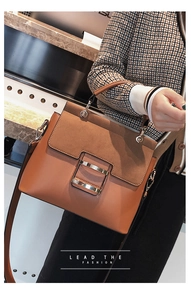 Caramel crossbody bag detail showing leather texture and gold metal buckle on model