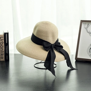 Elegant beige straw sun hat with black ribbon bow, French retro style for beach vacations