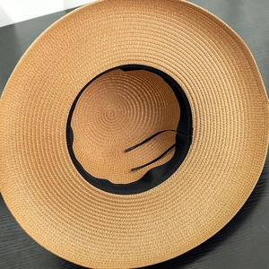 Detail of woven straw sun hat showing interior sweatband and adjustable drawstring