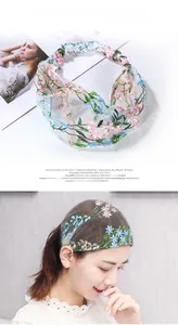 Detail of floral embroidery on wide lace headband shown with model wearing style