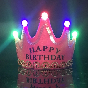 Close-up of pink LED crown hat with Happy Birthday text and colorful glowing lights