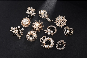Elegant collection of pearl and crystal brooches in various designs for formal attire.