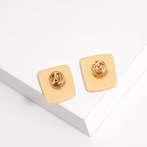 Detail of the golden metal pin back with standard butterfly clutch fastener on a clean background