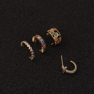 Macro shot of gold star earrings with colorful cubic zirconia and honeycomb details
