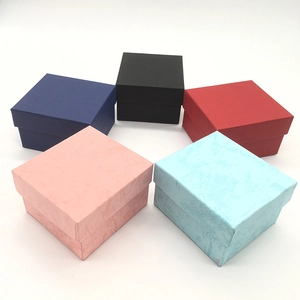 Square paper watch gift boxes in five colors arranged in a circle on white background
