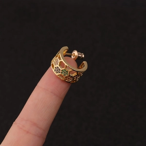 Detail of gold hexagon honeycomb earrings with colorful micro-inlaid zircons on finger