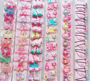 Flat lay view of colorful kids hair accessory sets with elastic bands and clips in packaging