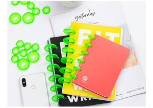Detail view of 28mm fluorescent green plastic discbound rings for mushroom hole planners