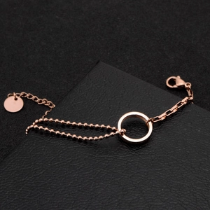 Detailed close-up of double-layer rose gold beaded bracelet with circular pendant on black box