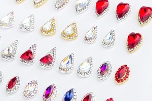 Detalle macro de adornos de cristal para uñas en forma de corazón, gota y marquesa