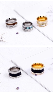 Close-up of stainless steel rings with shell inlays and double rows of crystals