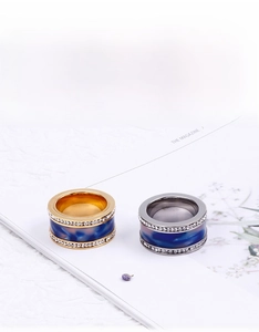Close-up of gold and silver steel rings featuring blue marble inlay and pave zircons