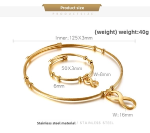 Detail of infinity symbol charms on golden stainless steel necklace and ring set