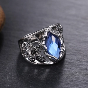 Macro shot of marquise-cut blue crystal ring with intricate hollow leaf silver band
