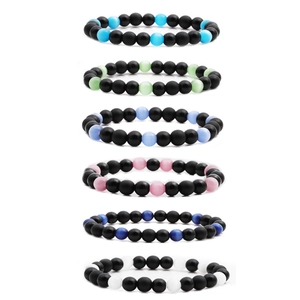 Detailed stack of beaded bracelets featuring matte black stones and colorful opal beads