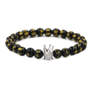 Macro detail of 8mm black stone prayer beads with a silver crown charm and white zircons