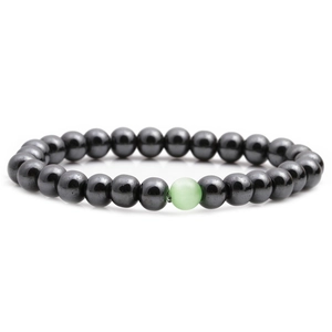 Macro detail of hematite beaded bracelet featuring a single green cat eye stone accent