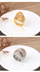 Detailed view of layered hollow gold ring and tri-color pavé zircon band on a porcelain dish