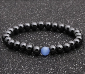 Macro shot of hematite beaded bracelet featuring a single blue cat-eye stone bead