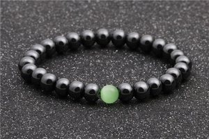 Detail shot of hematite beaded bracelet featuring a single green cat-eye stone accent