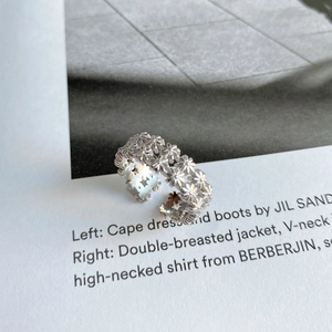 Detailed close-up of a hollow daisy flower ring in 925 sterling silver with open design