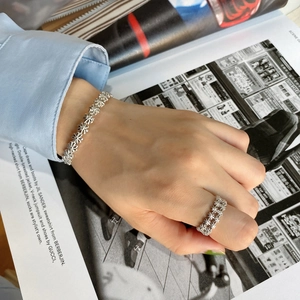 Detail of 925 sterling silver daisy ring and bracelet set with floral cutouts
