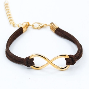 Gros plan détaillé du symbole infini doré sur un bracelet en cordon de cuir marron