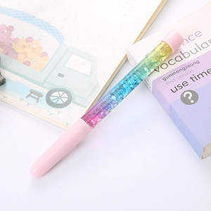 Creative liquid quicksand neutral pen with pink accents and pastel gradient glitter on a desk
