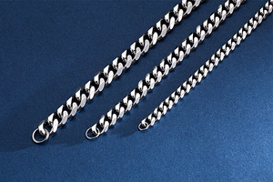 Close-up of polished stainless steel Cuban link chains in three different widths