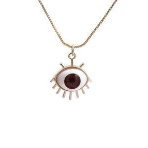 Golden evil eye necklace with brown pupil and eyelash details on white background