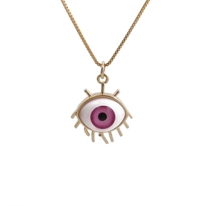 Detail of evil eye pendant with purple gradient center and golden eyelash lines