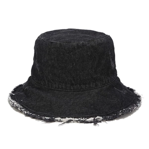 Detailed view of the distressed raw edges and twill texture on a black denim bucket hat