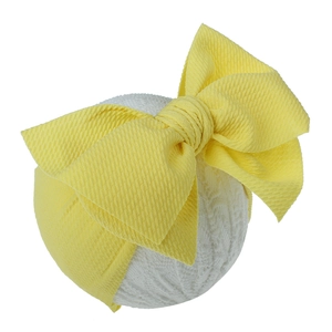 Detailed macro view of vibrant yellow textured fabric bow headband for baby girls