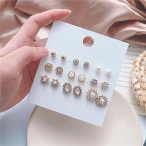 Macro shot of 9 pairs golden earring set with pearls and crystals on display card